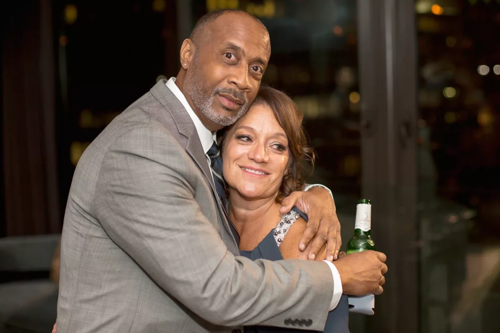 A man and woman hugging each other at an event.