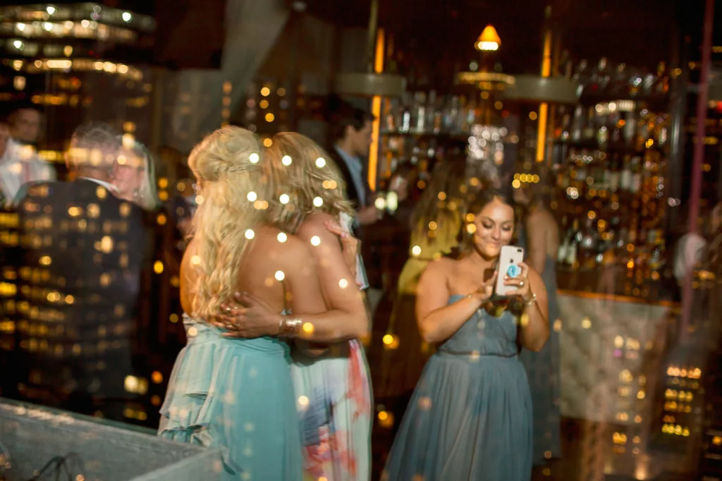 A group of bridesmaids standing in front of a window at night at The Skylark in NYC.