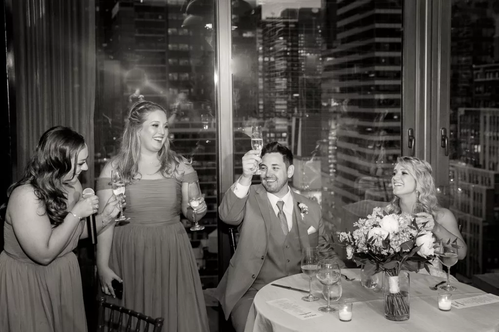 A black and white photo of bridesmaids toasting at a wedding at The Skylark in NYC.