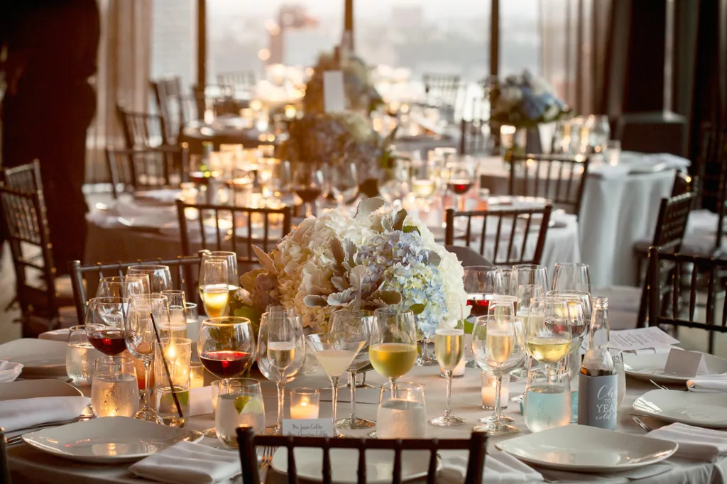 A table with white linens and wine glasses.
