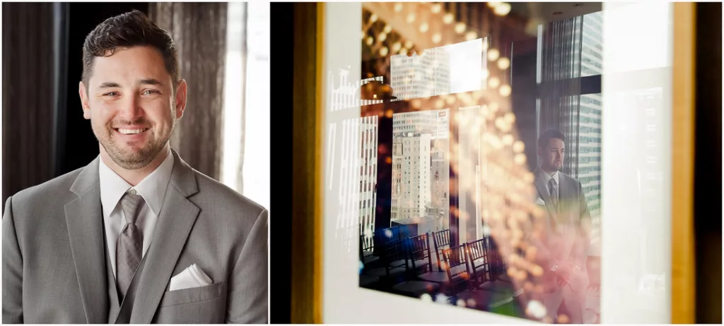 A man in a suit smiles in front of a framed picture.